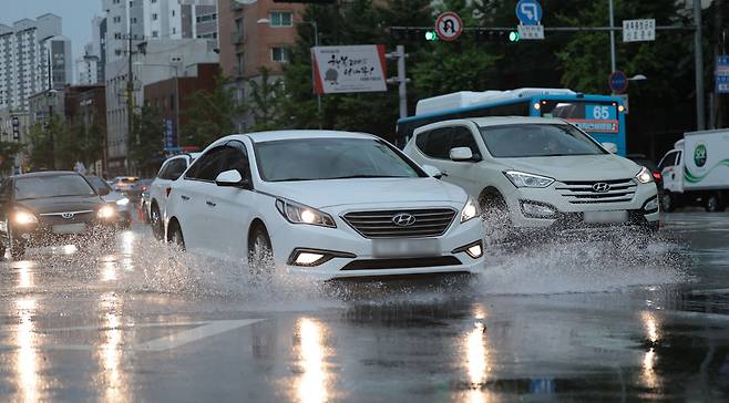 돌풍과 천둥·번개를 동반한 강한 비가 내리는 17일 서울 서대문구 북가좌동에서 도로에 고인 빗물 위를 지나는 차량이 물보라를 일으키고 있다. 연합뉴스.