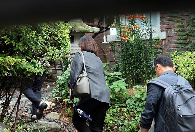 Investigators from the special counsel team led by Min Joong-ki, who is probing allegations surrounding former first lady Kim Keon Hee, enter the temple of Jeon Seong-bae, a shaman known as Geonjin, in Yeoksam-dong, southern Seoul, on July 15 during a raid. [JOINT PRESS CORPS]