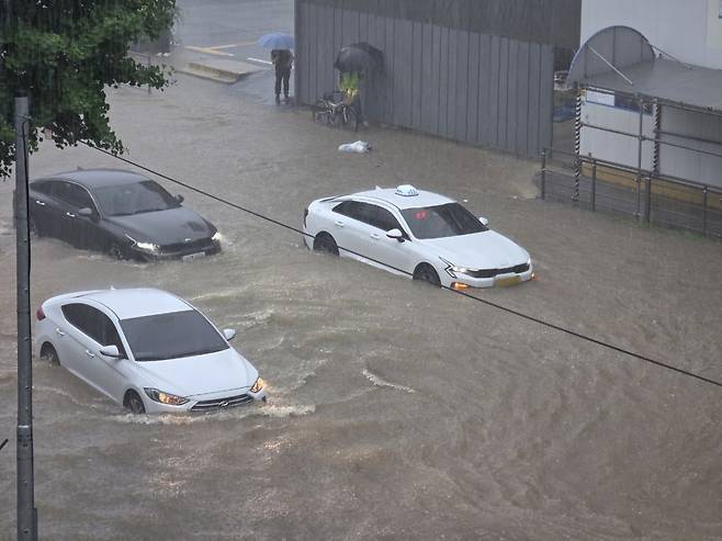 호우경보가 발효된 17일 광주 북구 용봉동 북구청사 앞 도로가 침수돼 차량이 멈춰서있다. 연합뉴스