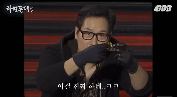 ▲ 라면꼰대5에서 '파김치갱' 시그니처 포즈를 취하고 있는 김풍 작가. 손에서 감고 있는 건 파김치다. 유튜브 갈무리