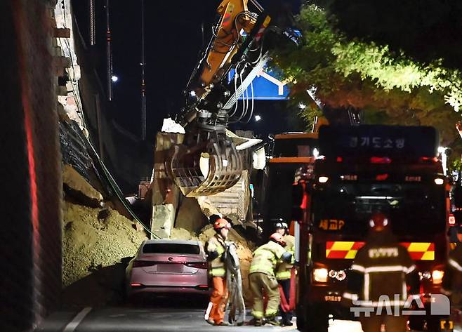 [오산=뉴시스] 김종택 기자 = 수도권 등 중부지역에 호우주의보가 발효된 16일 오후 경기 오산시 가장교차로 고가도로 옹벽이 무너져 소방관들이 매몰된 차량을 구조작업하고 있다. 2025.07.16. jtk@newsis.com