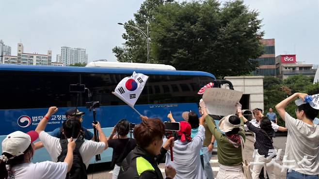 지난 7일 오후 2시 10분 서울 마포구 서울서부지법 정문 앞으로 진입하는 피고인들의 호송 차량을 향해 지지자들이 응원하는 모습. 김수정 기자