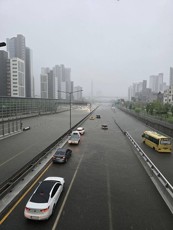 17일 오전 출근길에 아산시 배방읍 장재리 국도 21호선에서 지하차도가 아닌 지대가 낮은 지점의 도로가 침수된 가운데 운전자들이 도로를 통과하지 못하고 있다. 독자제공