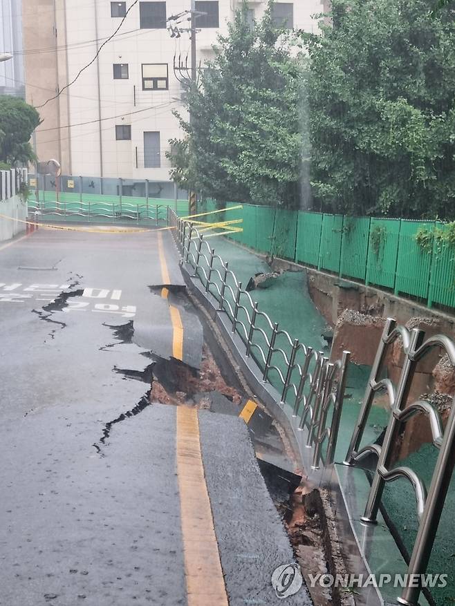 쩍쩍 갈라진 도로와 주저앉은 인도 (광주=연합뉴스) 호우경보가 발효된 17일 광주 동구 계림동 한 도로와 인도가 집중호우에 폭삭 주저앉거나 갈라져 있다. 2025.7.17 [독자 제공. 재판매 및 DB 금지] in@yna.co.kr