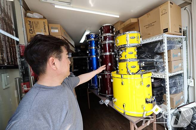 18일 광주 북구 용봉동동 전남대 후문 일대가 전날 내린 폭우로 침수돼 한 악기상가의 상인이 물에 젖은 드럼통을 대피시키고 있다. 2025.7.18/뉴스1 ⓒ News1 박지현 기자