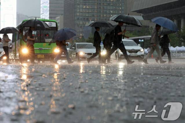 전국에 강한 비가 내린 17일 오전 서울 광화문광장에서 시민들이 물 고인 도로를 지나고 있다. 2025.7.17/뉴스1 ⓒ News1 신웅수 기자