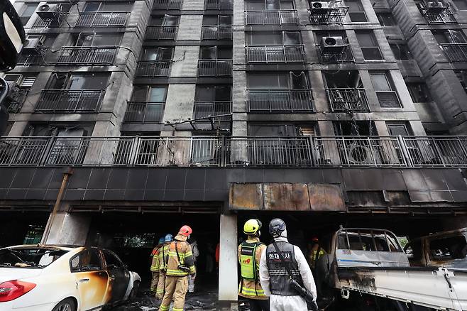전날 주차장에서 발생한 화재로 다수의 인명피해가 발생한 경기도 광명시 소하동 한 아파트에서 18일 경찰과 소방 등 관계자들이 현장을 살펴보고 있다. /연합뉴스