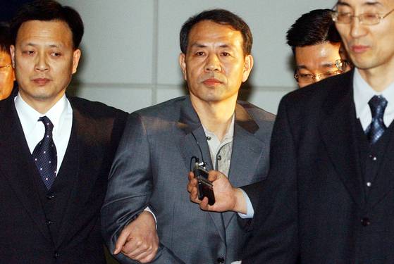 해외도피 중 미국에서 붙잡힌 최성규 총경이 2004년 3월 인천국제공항을 통해 압송되고 있다. 중앙포토