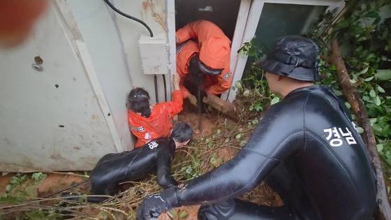 지난 17일 오후 산청군 신등면 간공리 연산마을에서 발생한 산사태로 주택에 거주하는 60대 여성이 토사에 깔려 소방대원들이 구조하고 있다. 사진 경남소방본부