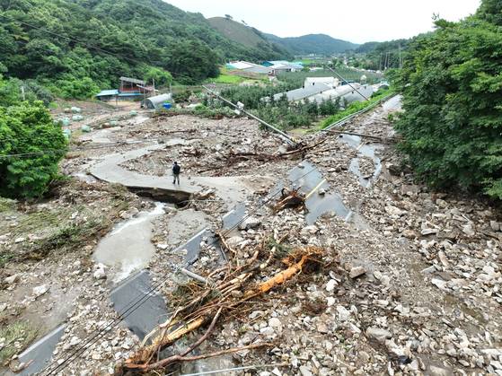 Bongun-ro in Bongsan-myeon, Yesan County, South Chungcheong, is covered in mud and debris following a landslide as heavy rain hit central regions on July 17. [YONHAP]