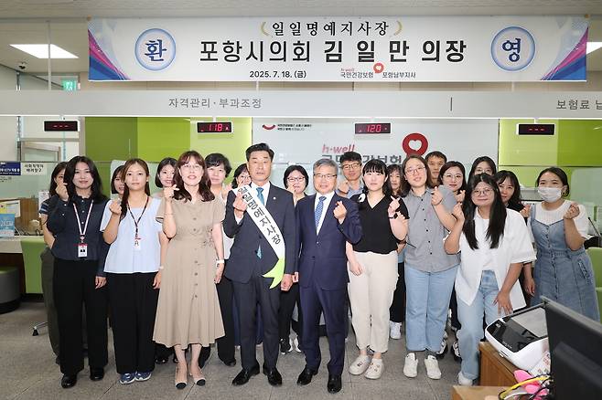 김일만 포항시 의회의장이 국민건강보험공단 포항남부지사 일일 명예지사장으로  위촉,기념사진을 찍고 있다.[포항시 의회제공]