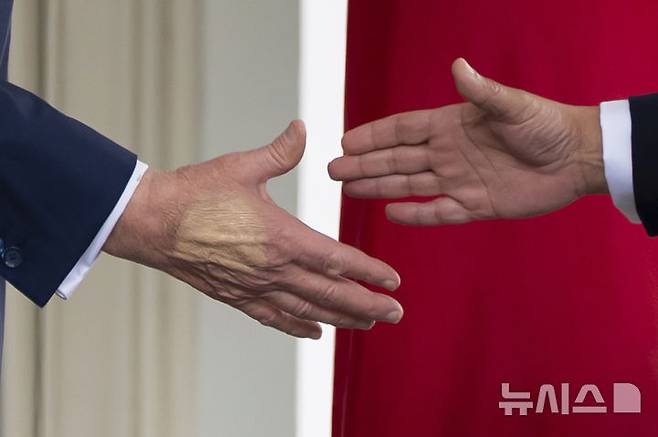 [워싱턴=AP/뉴시스] 지난 16일(현지 시간) 도널드 트럼프 대통령이 백악관 집무실에서 살만 빈 하마드 알 칼리파 바레인 왕세자 겸 총리와 회담에 앞서 악수하고 있다. 트럼프 대통령의 손에는 멍 자국을 가리기 위한 화장품이 덧발려 있다. 올해 79세인 트럼프 대통령이 종아리 붓는 증상으로 종합 검진한 결과 만성 정맥부전을 진단받았다. 2025.07.18.