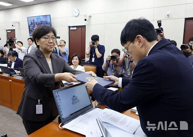 [서울=뉴시스] 고승민 기자 = 정은경 보건복지부 장관 후보자가 18일 서울 여의도 국회 보건복지위원회에서 열린 인사청문회에서 박주민 위원장에게 선서문을 제출하고 있다. 2025.07.18. kkssmm99@newsis.com