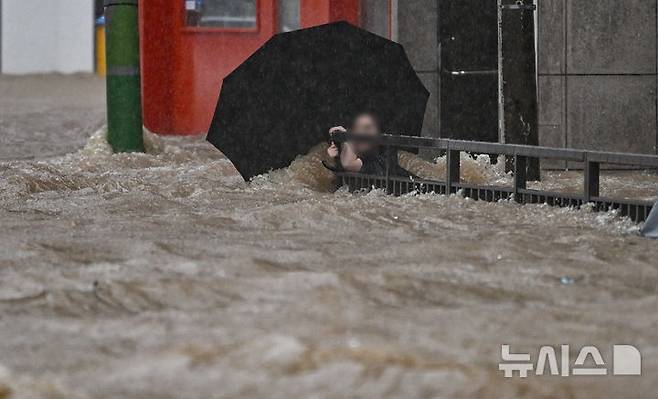 [광주=뉴시스] 이영주 기자 = 광주지역에 하루 최고 311㎜ 폭우가 쏟아진 17일 오후 침수된 광주 북구청 앞 도로에서 한 시민이 물살에 휩쓸리고 있다. 2025.07.17. leeyj2578@newsis.com