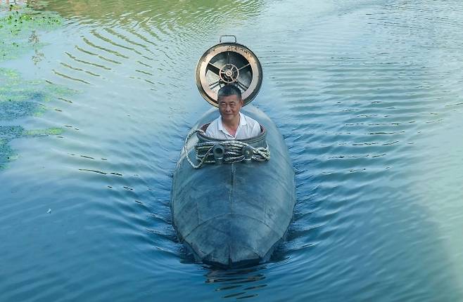 지난 2일 장 씨가 자신이 직접 만든 잠수함을 중국 안후이성의 한 강에서 조종하고 있다.  AFP 연합뉴스