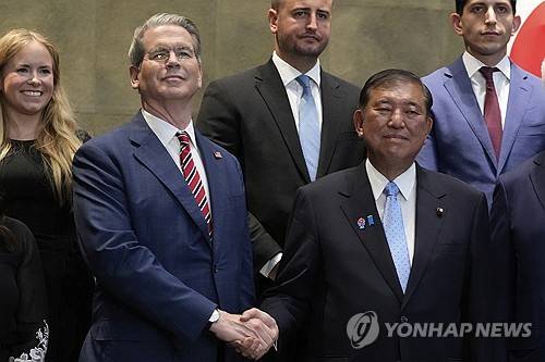 이시바 시게루(첫째줄 오른쪽) 일본 총리와 스콧 베선트 미국 재무부 장관이 18일 일본 도쿄에서 만나 악수하고 있다. AP연합뉴스