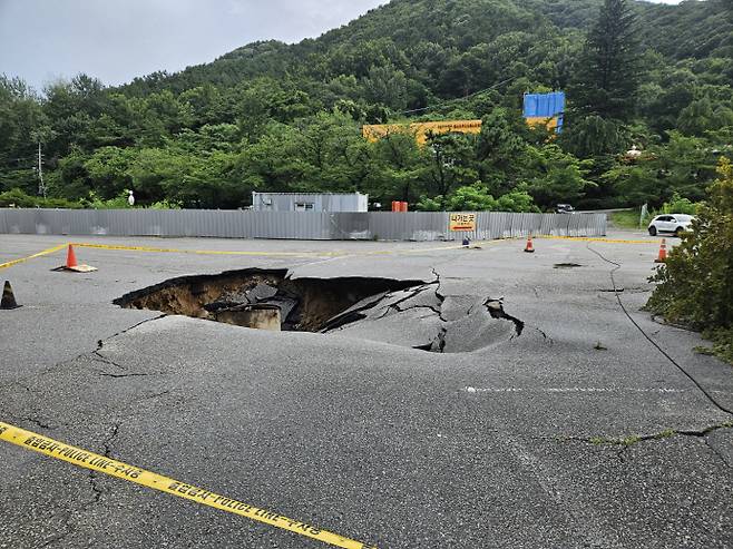 광주에 사흘간 478㎜가 넘는 폭우가 쏟아지면서 지반침하(싱크홀)가 곳곳에서 발생했다. 사진은 지난 17일 광주 동구 지산동 한 호텔 도로에서 대형 싱크홀이 발생해 통제된 모습. /연합뉴스