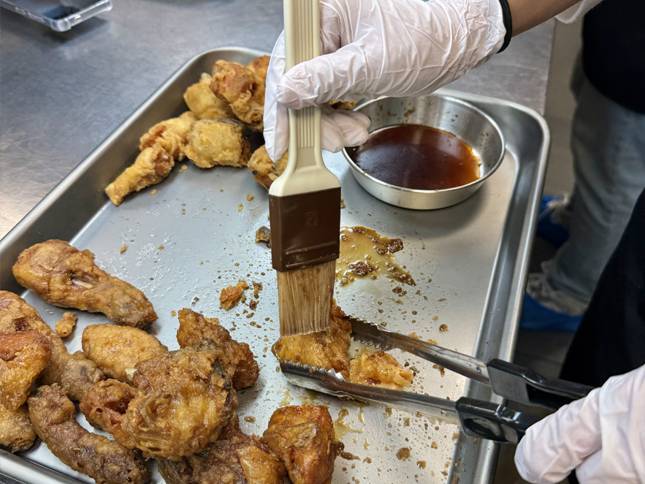 기자가 튀긴 닭에 직접 간장 소스를 바르고 있는 모습./사진=윤서영 기자 sy@