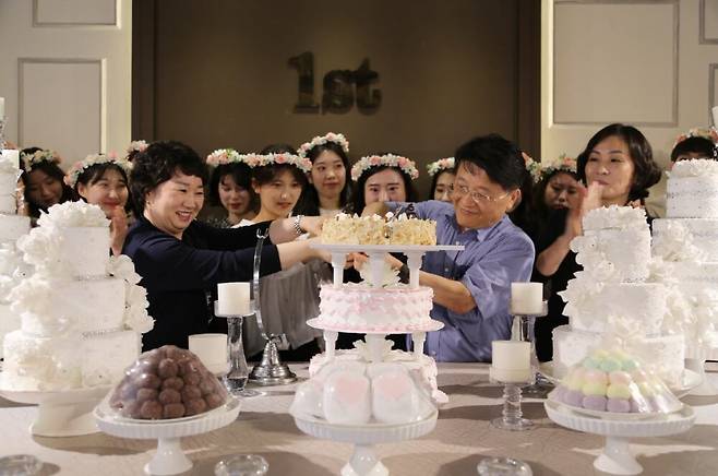 한 대학병원이 입사 1년 된 신규 간호사들을 위해 '돌잔치'를 열고 병원장과 수간호사 등이 케이크를 잘라주고있다. 수수팥떡과 백설기, 촛대로 진짜 돌상처럼 꾸몄다. /국제성모병원