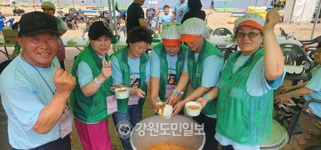 ▲ 고성군 천진리 새마을부녀회원들이 오랫동안 끓인 섭죽을 피서객들에게 무료로 나눠주고 있다.