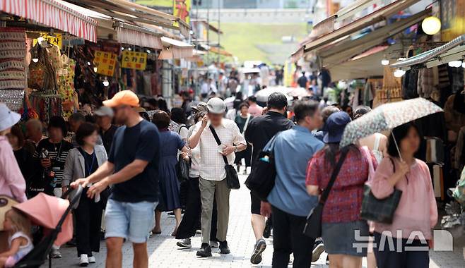 [서울=뉴시스] 김선웅 기자 = 서울 시내 상점가에서 시민들이 오가고 있다. 2025.06.19. mangusta@newsis.com