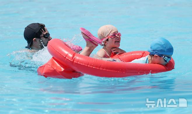 [서울=뉴시스] 김진아 기자 = 서울의 낮 최고 기온이 32도까지 오르는 무더운 날씨를 보인 23일 서울 서초구 잠원한강공원 수영장을 찾은 외국인 가족이 즐거운 시간을 보내고 있다. 2025.06.23. bluesoda@newsis.com