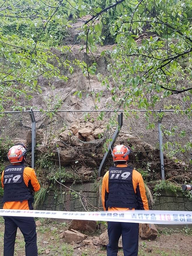 [부산=뉴시스] 19일 오후 3시47분께 강서구의 한 도로 비탈면에서 낙석이 발생해 소방당국이 통제선을 설치하는 등 안전조치에 나섰다. (사진=부산소방재난본부 제공) 2025.07.19. photo@newsis.com *재판매 및 DB 금지