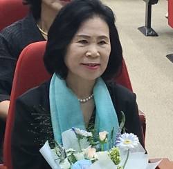 김행금 천안시의회의장이 지난 19일 출판기념회 행사장에서 꽃다발을 들고 앉아 있는 모습.