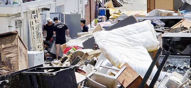 지난 17일부터 광주·전남에 최대 600㎜ 이상의 극한호우가 쏟아져 주택, 상가, 도로 곳곳이 침수된 가운데 20일 광주 북구 신안교 인근 마을에서 시민들이 흙탕물이 채 마르지 않은 물건들을 쌓아놓고 복구작업에 구슬땀을 흘리고 있다./김애리 기자