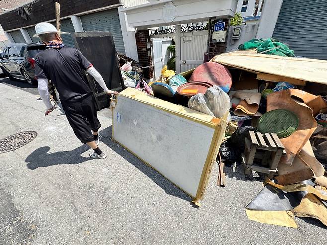 신안동 주민 김모씨(70대)가 하수도 물이 스며든 집안 자재들을 집 앞에 내놓고 있다. /임지섭 기자 ljs@namdonews.com
