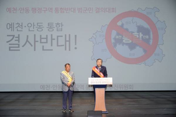 18일 예천군문화회관에서 열린 '안동·예천 행정구역 통합 반대 범군민 결의대회'에 참석한 도기욱·이형식 경북도의회 의원들이 통합에 대한 반대 입장을 연단에서 밝히고 있는 장면