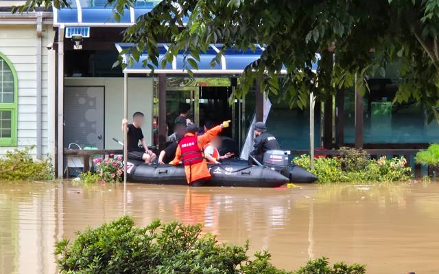 19일 오후 의령군 대의면 집중호우로 인해 마을이 침수돼 출동한 소방대원들이 보트를 이용해 건물에 고립된 마을 주민을 구조하고 있다./소방청/