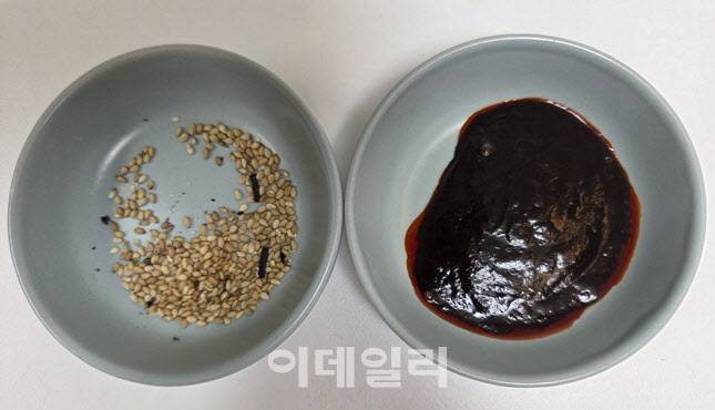 모방 제품의 건더기와 액상소스. 김가루는 세 조각 남짓, 참깨도 소량이며, 소스 점도는 정품 대비 묽고 광택이 부족하다. (사진=한전진 기자)