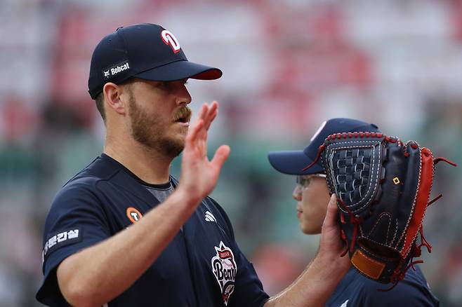 두산 콜 어빈이 19일 인천SSG랜더스필드에서 열린 2025 KBO리그 정규시즌 SSG전에서 이닝을 마치고 더그아웃에 들어오며 동료들과 하이파이브를 하고 있다. 사진 | 두산 베어스