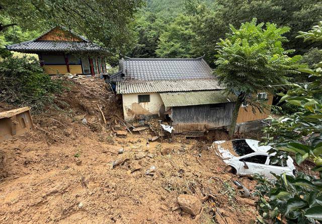 18일 경북 청도군 청도읍 구미리 주택 옆에 차량 한 대가 전날 집중호우 때 쏟아진 토사에 파묻혀 있다. 청도=뉴스1