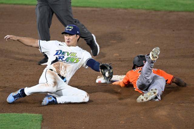 김하성이 볼티모어전 9회 수비 때 상대 세드릭 멀린스의 도루를 저지하기 위해 포수 송구를 힘겹게 받고 있다. 탬파=AP 뉴시스