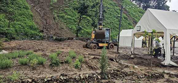 포크레인으로 빗물로 흘려내린 토사를 제거하고 있다. [사진=포천시]