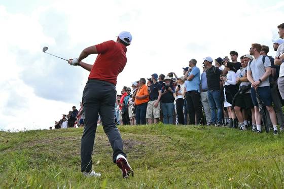 매킬로이가 11번 홀 러프에서 아이언샷을 하고 있다. 매킬로이의 오른쪽 바지 주머니 옆에 땅에서 튀어나온 볼이 보인다. AFP=연합뉴스