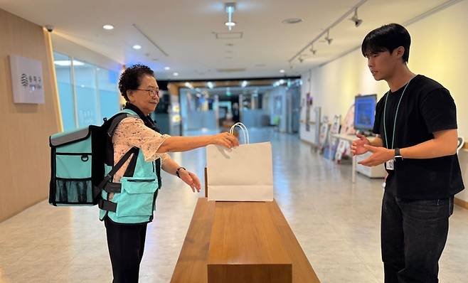 서울 송파구의 한 시니어가 배달의민족 도보 배달원 입문 교육을 받은 후 실제 배달 체험에 나서고 있다. 사진=우아한청년들