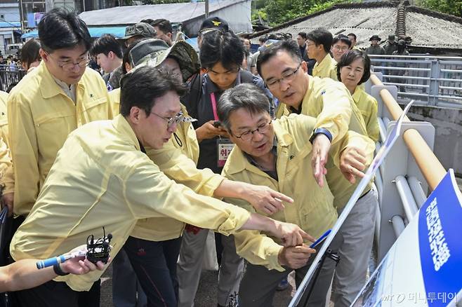 김민석 국무총리가 20일 집중호우로 침수피해를 입은 광주 북구 신안교 현장을 찾아 피해 현황을 보고받고 있다. 김 총리는 관계자들과 함께 침수 원인과 향후 복구 계획에 대해 논의하며, 주민 불편 최소화를 위한 대책 마련을 주문했다./사진=뉴시스