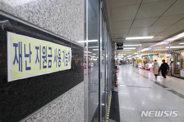 [서울=뉴시스] 박미소 기자 = 정부가 신종 코로나바이러스 감염증(코로나19) 확산에 대응한 맞춤형 피해지원 대책을 발표한 29일 오후 서울 중구 명동지하 상가에 재난지원금 사용 가능처 안내문이 붙어있다. 3차 재난지원금은 소상공인 버팀목자금 4조 1천억원, 특수형태근로종사자와 프리랜서 등 고용 취약계층 소득안정자금 등으로 구성됐다. 2020.12.29. misocamera@newsis.com