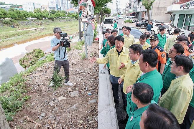 [당진=뉴시스] 윤호중 행정안전부 장관이 20일 폭우 피해를 겪은 충남 당진전통시장을 찾아 오성환 시장으로부터 지난해 시가 당진천 범람을 막기 위해 설치한 차수매트에 관한 설명을 듣고 있다. (사진=당진시 제공) 2025.07.20. photo@newsis.com *재판매 및 DB 금지