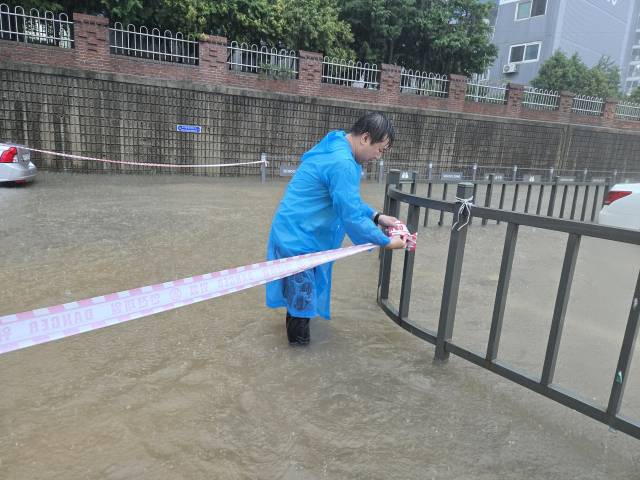 지난 17일 광주 금호동 어린이보호구역이 침수된 가운데 안형주 광주 서구의원이 현장에서 차량 통제를 위해 안전 줄을 설치하고 있다. 사진 제공=독자