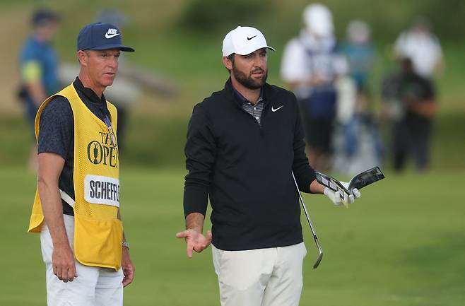 스코티 셰플러(오른쪽)가 20일 영국 북아일랜드 포트러시의 로열 포트러시GC에서 열린 제153회 디 오픈 3라운드 12번홀에서 캐디 테드 스콧과 홀 공략을 앞두고 정보를 나누고 있다.  포트러시｜마이크 프레이 이매진 이미지스 연합뉴스