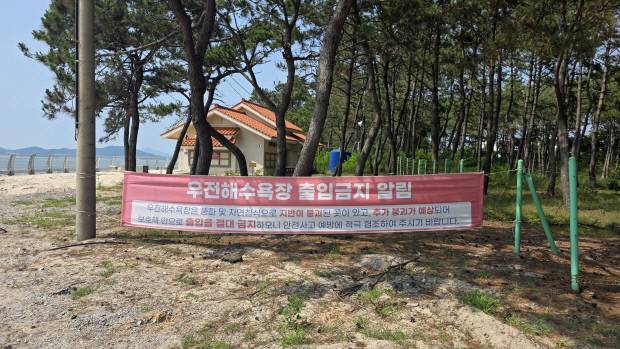 신안 증도 우전 해수욕장 중앙 통행로에 설치된 ‘우전해수욕장 출입금지’ 알림 현수막. 현수막에는 해수욕장의 풍파 및 자연침식에 따른 지반 붕괴 우려 등으로 안전사고 예방 차원에서 출입을 절대 금지한다는 내용이 적혀 있다.