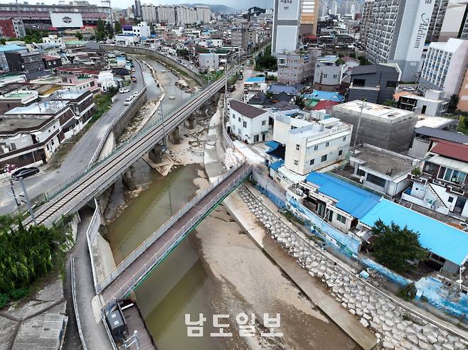 수마가 할퀴고 간 광주 도심이상 기후로 인해 '극한호우'가 일상이 된 현재, 광주 침수 피해 등을 예방하기 위해서는 치수(治水) 인프라를 단기 대책 보다는 '중장기' 대책으로 변환해 나가야 한다는 지적이 나온다. 사진은 21일 광주광역시 북구 신안교(서방천) 인근 옹벽이 최근 내린 폭우로 무너져 관계자들이 임시 복구 조치를 실시한 모습. /임문철 기자 35mm@namdonews.com