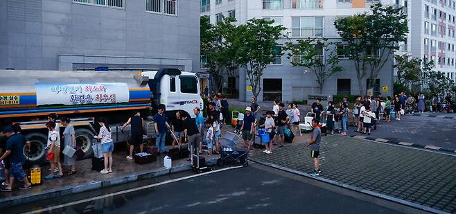 집중호우로 인한 상수도관 파손으로 단수 피해가 이어지고 있는 21일 울주군 언양읍의 한 아파트 단지에서 주민들이 살수차의 물을 받기 위해 줄을 서 있다. &nbsp;최지원 기자