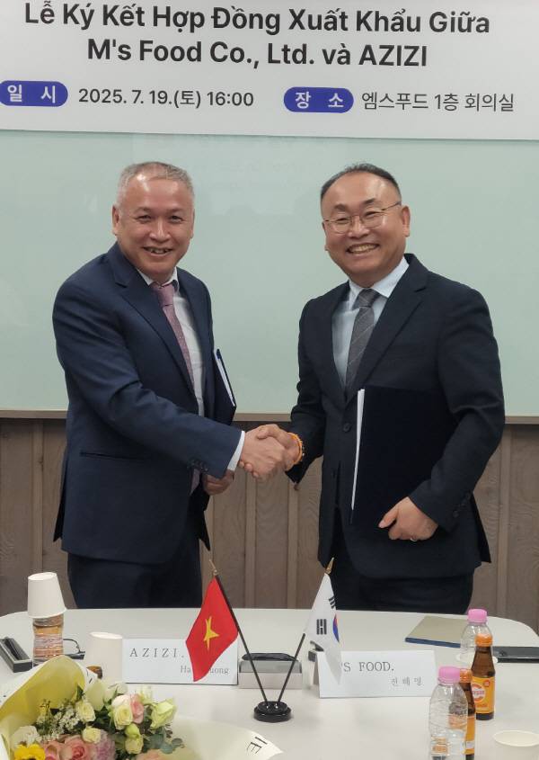 엠스푸드 전해명 대표(오른쪽)가 베트남 식품유통업체 ZIZI㈜레티흐엉 대표(왼쪽)와 수출계약을 체결하고 악수를 하고 있다. 고령군