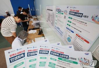 '민생회복 소비쿠폰'의 1차 신청 첫날인 21일 오전 경기 수원시 팔달구 인계동행정복지센터에서 시민들이 신청서를 작성하고 있다. 2025.7.21/뉴스1 ⓒ News1 김영운 기자