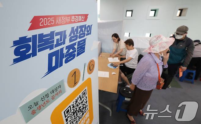 '민생회복 소비쿠폰'의 1차 신청 첫날인 21일 오전 경기 수원시 팔달구 인계동행정복지센터에서 시민들이 신청서를 작성하고 있다. 2025.7.21/뉴스1 ⓒ News1 김영운 기자